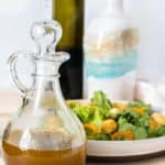 Bottle of homemade balsamic vinaigrette in front of a salad.