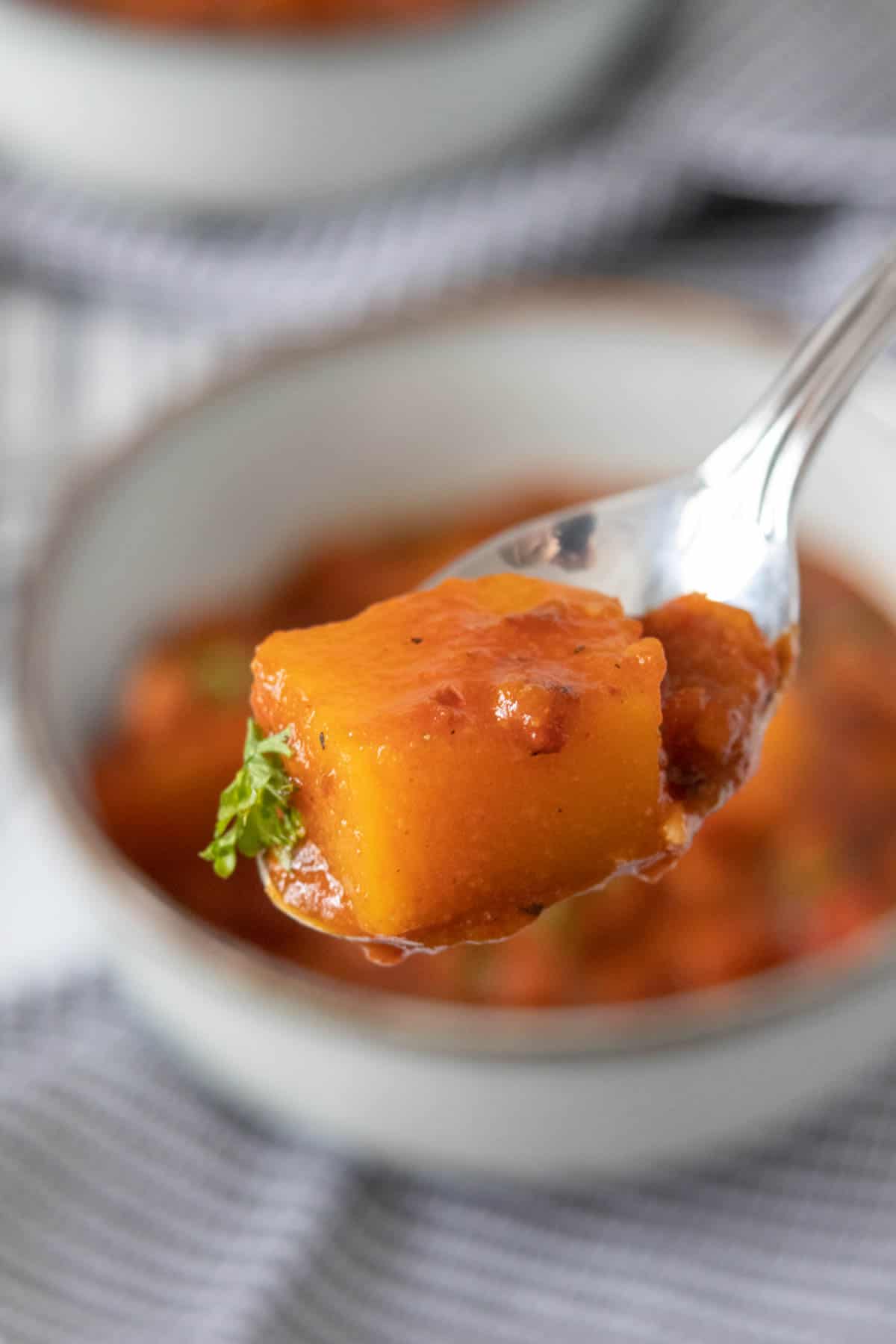 Close up of a butternut squash cube on a spoon.