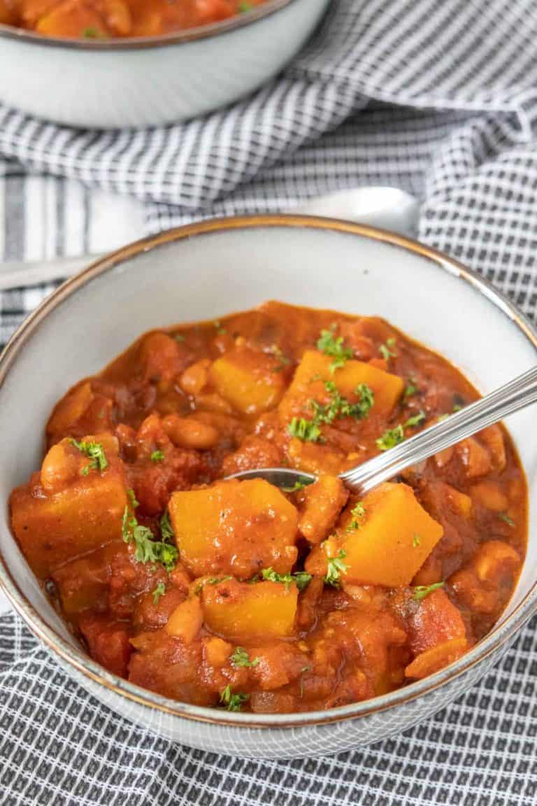Gray bowl of butternut squash chili with a spoon.
