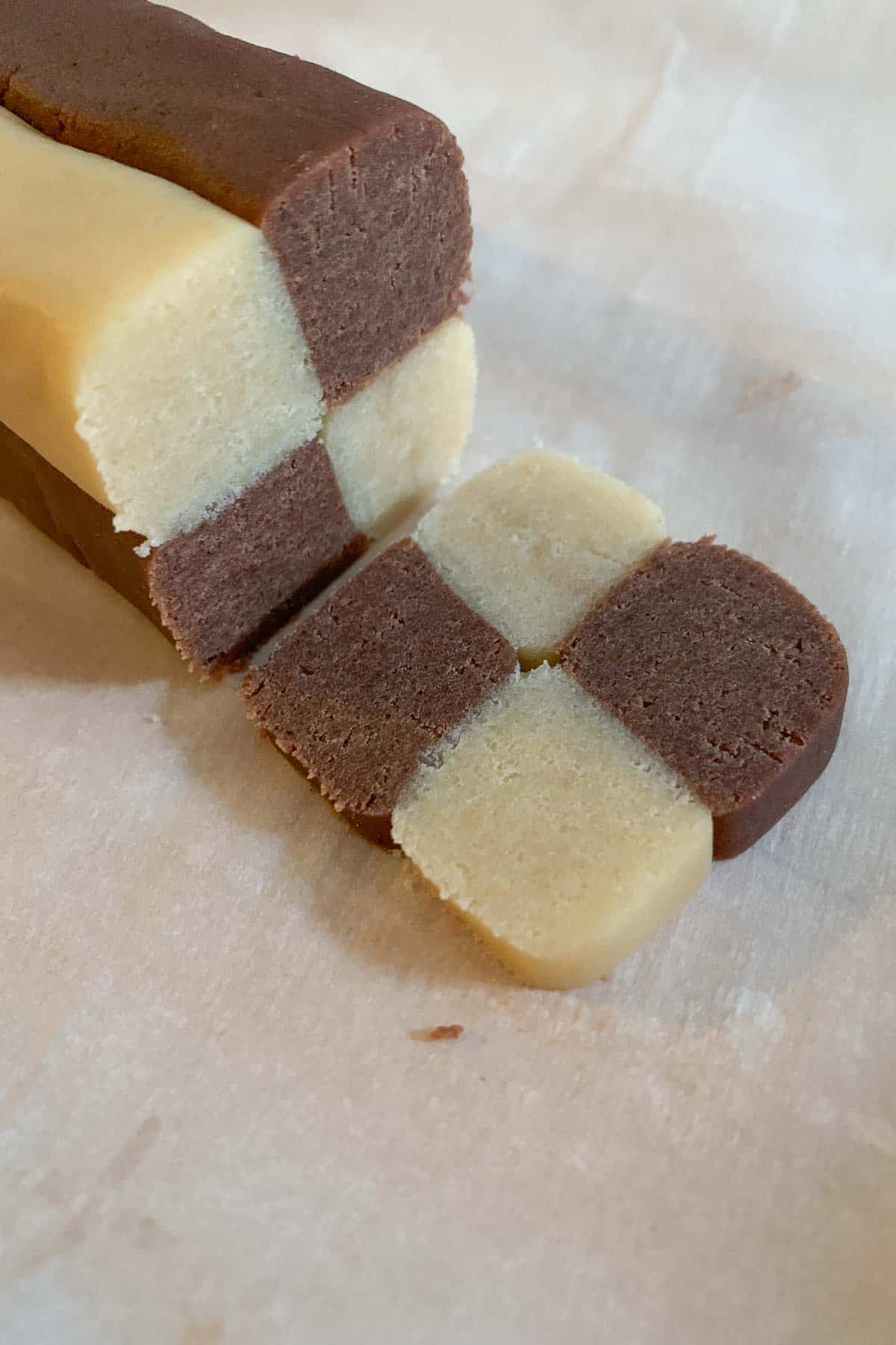 Log of checkerboard cookie dough with a slice.