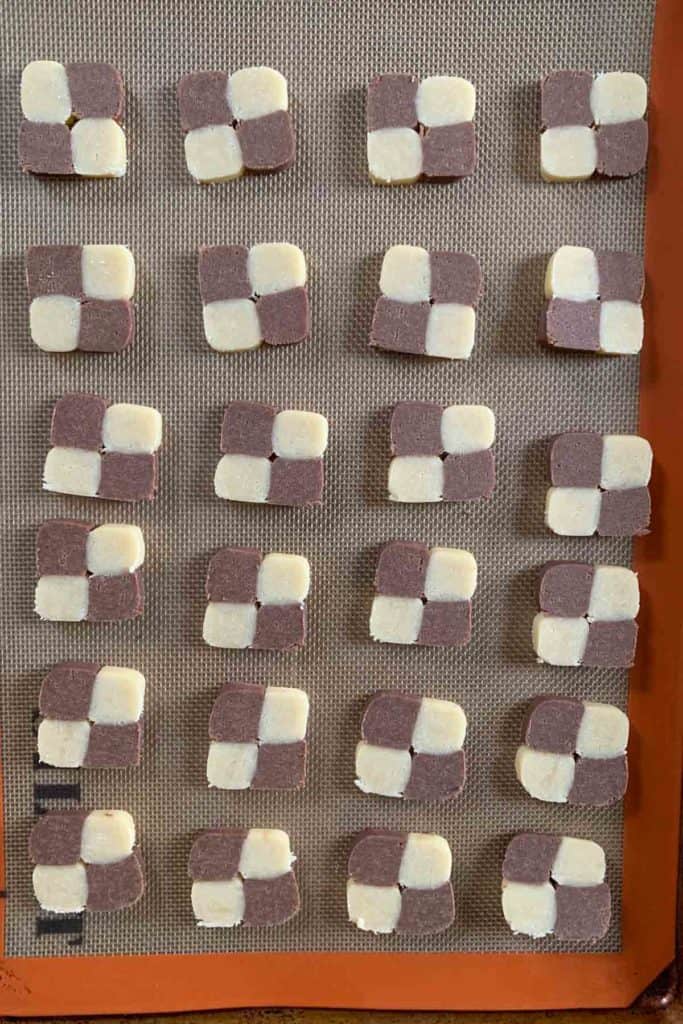 Unbaked checkerboard cookies on a baking sheet.