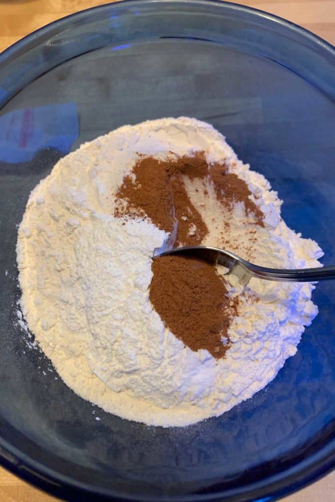 Mixing together dry ingredients for cranberry coffee cake in a blue mixing bowl.