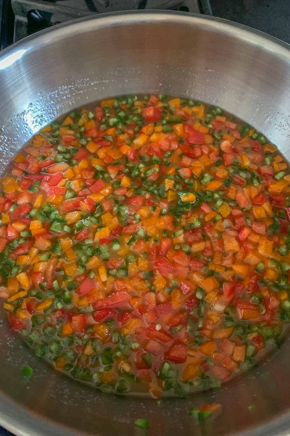 Cooking jalapeño jelly in a stainless pan.