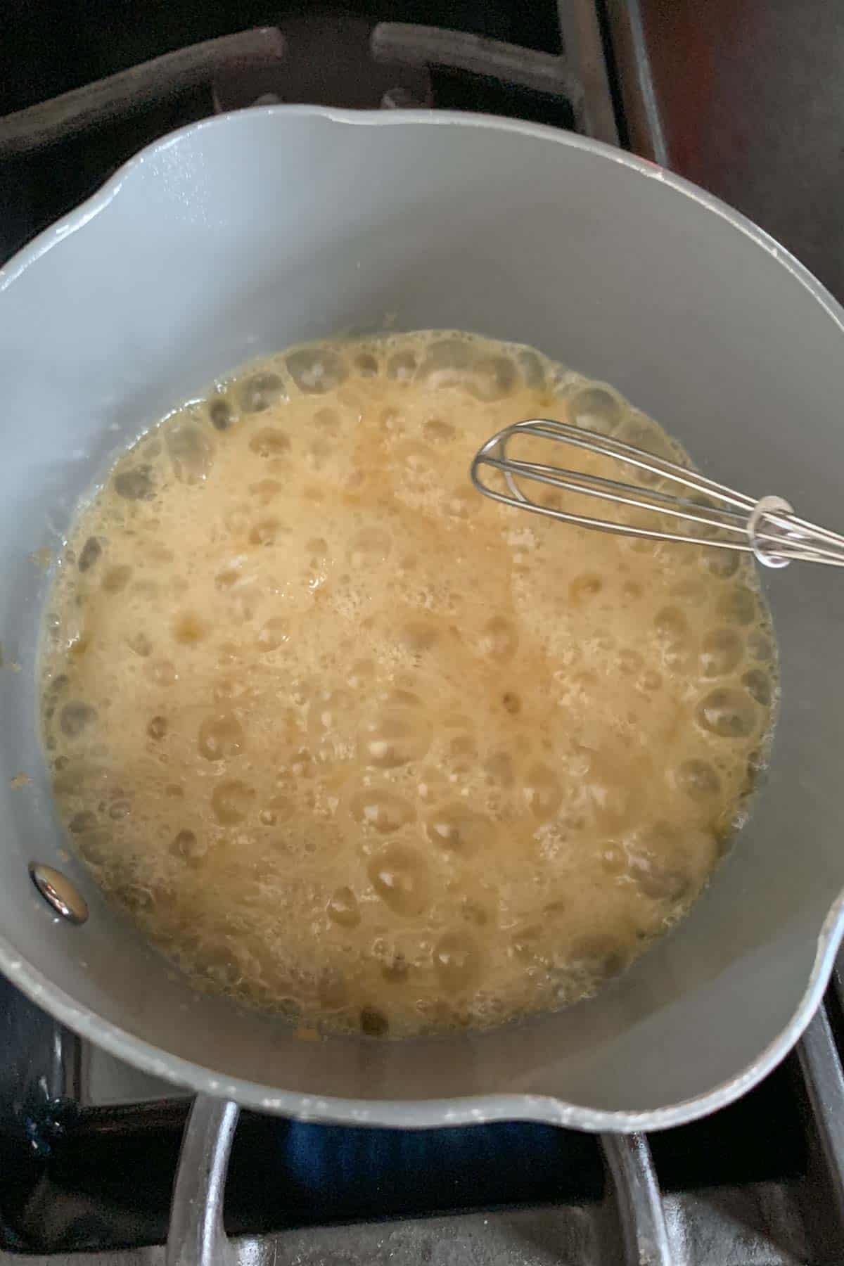 Saucepan with butterscotch sauce cooking.
