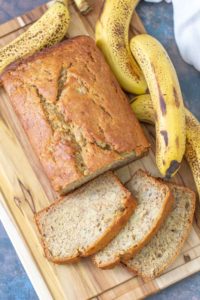 Loaf of banana bread with slices cut on a cutting board.