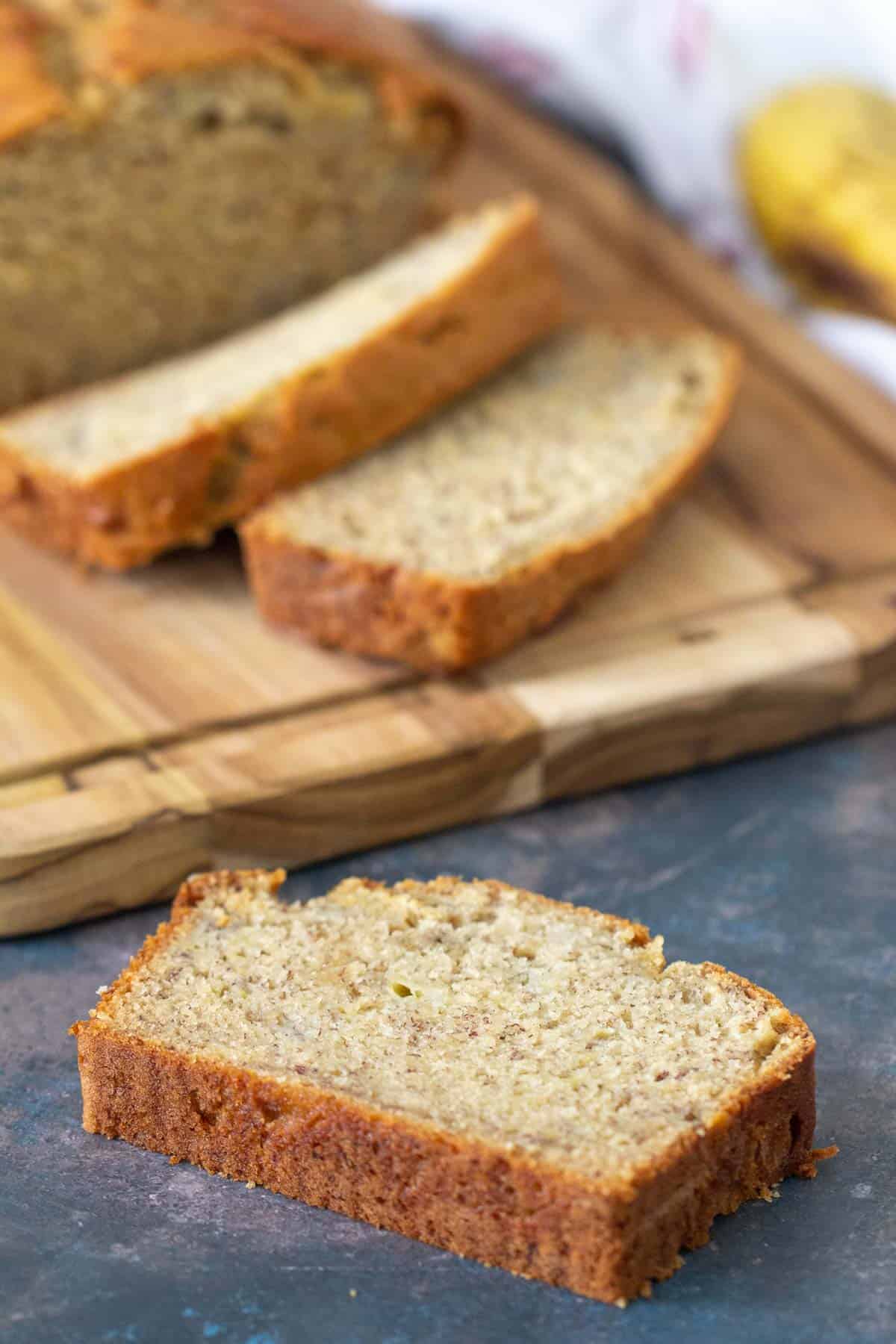 Slice of banana bread with other slices in the background.