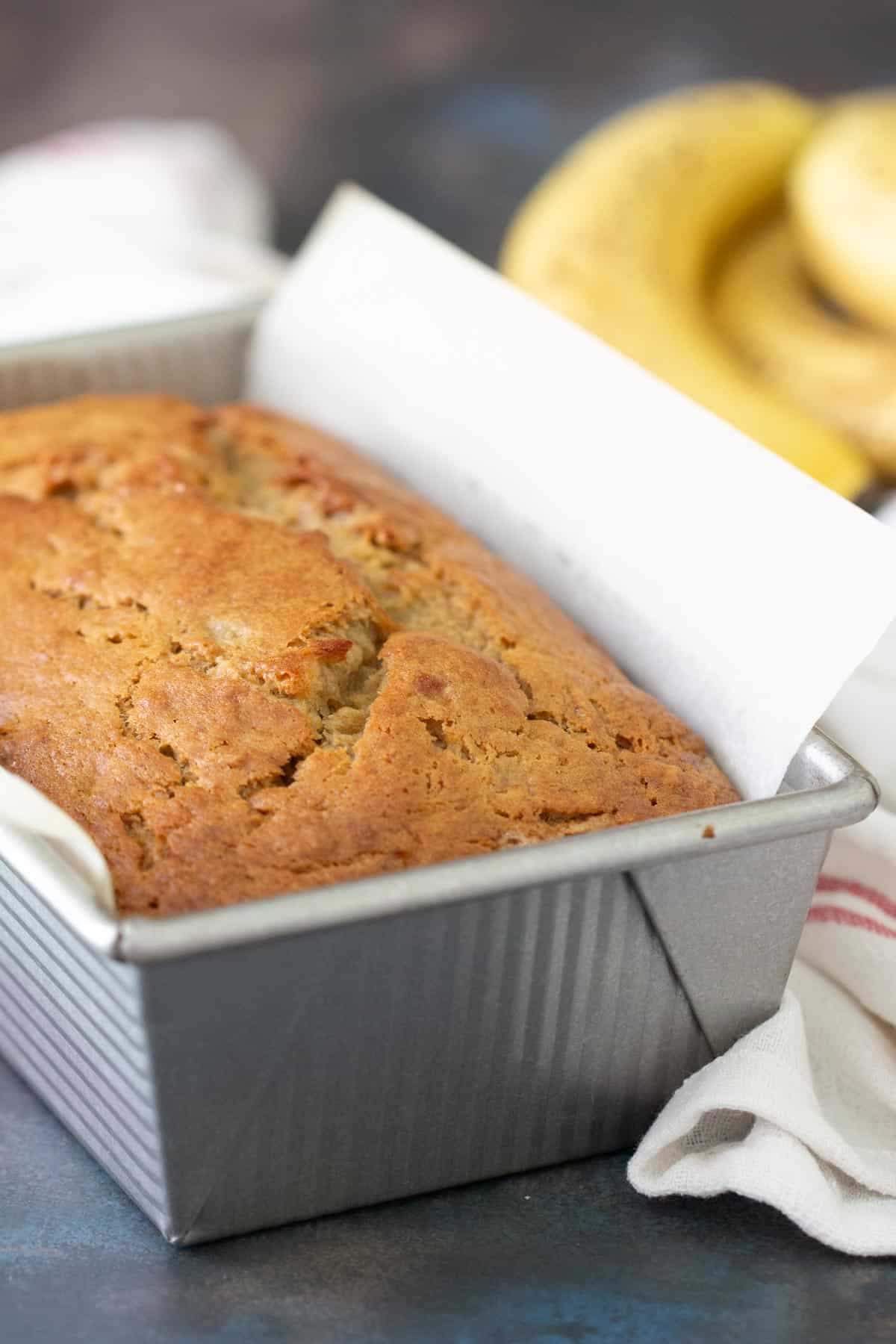 Baked banana bread in a metal loaf pan.