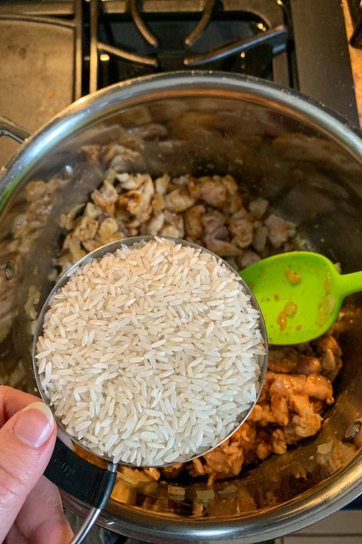 Adding rice to stock pot.