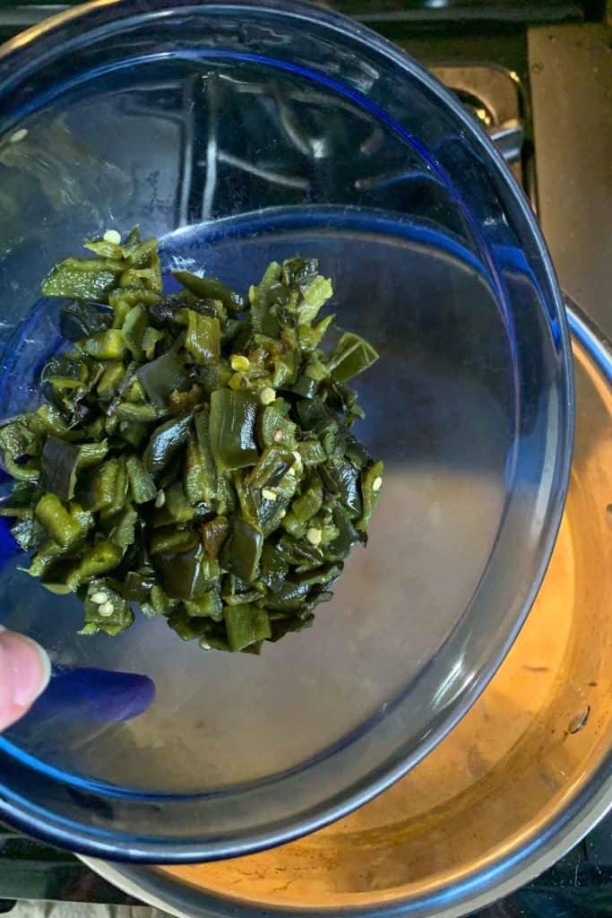 Adding chopped poblano peppers to saute pan.