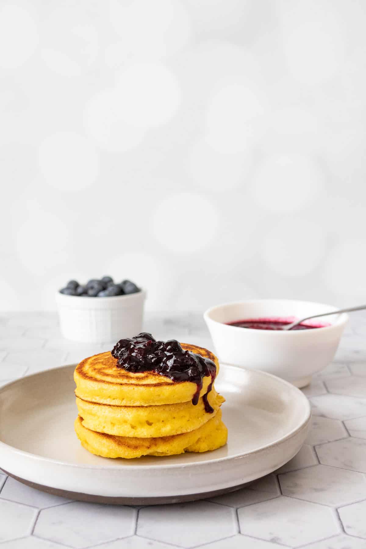 Cornmeal pancakes with blueberry sauce on top.