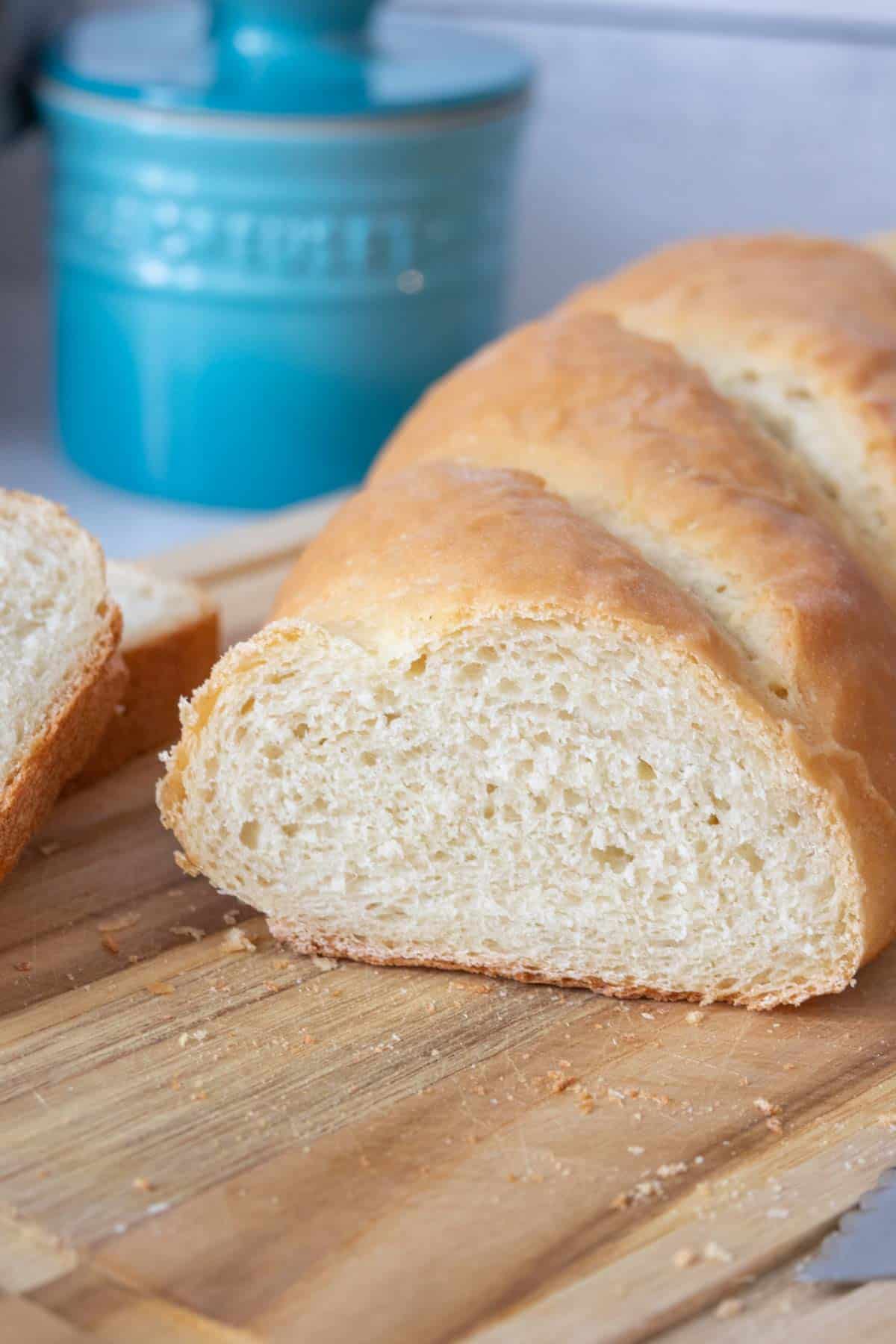 Cut loaf of French bread on a cutting board showing interior of bread.