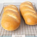 Two loaves of golden brown french bread cool on a wire rack, their crisp crusts inviting. A label at the bottom of the image reads "french bread.