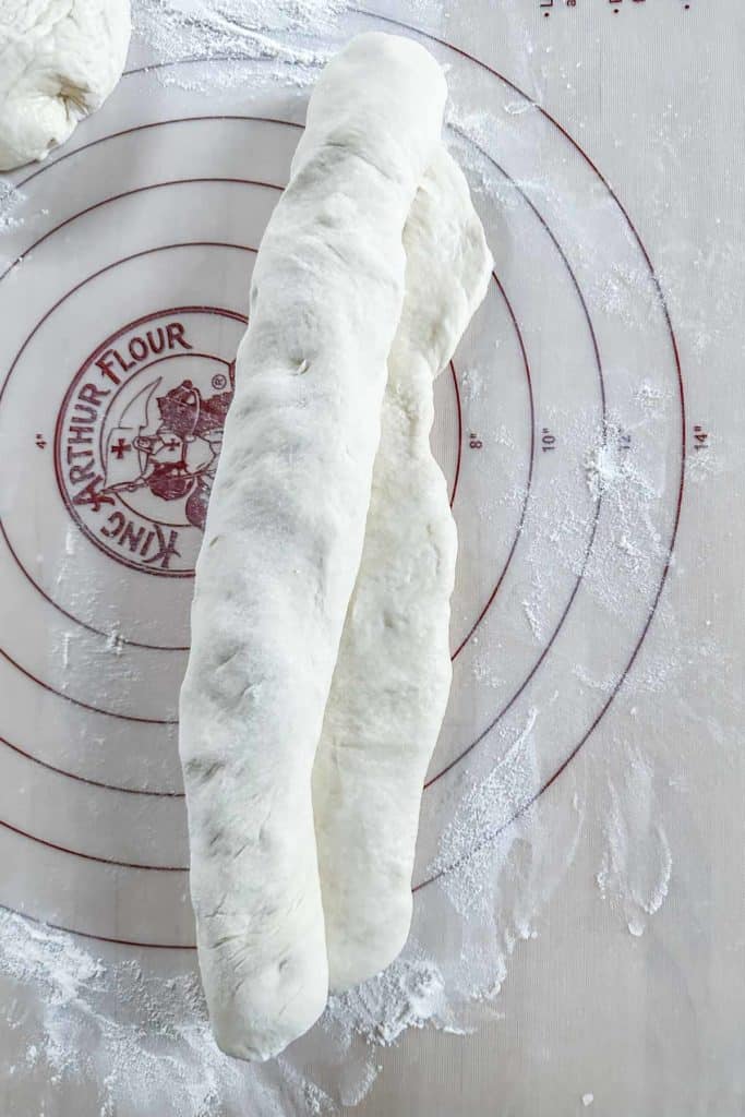 Rolling up unbaked dough to shape a loaf of bread.