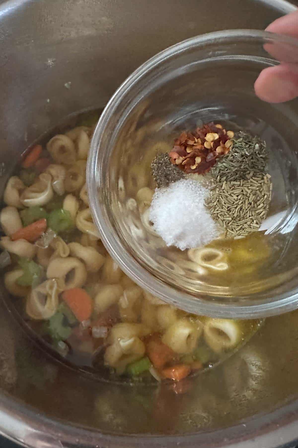 Adding spices to tortellini soup in instant pot.