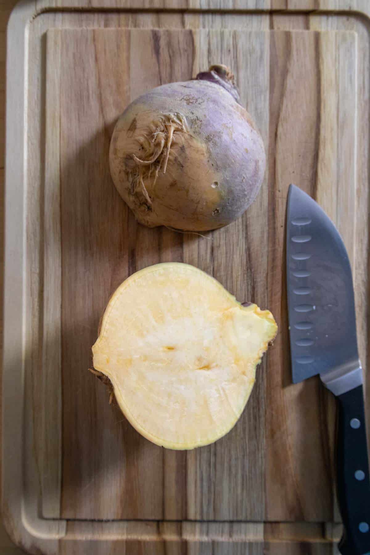 Halved rutabaga on a cutting board.