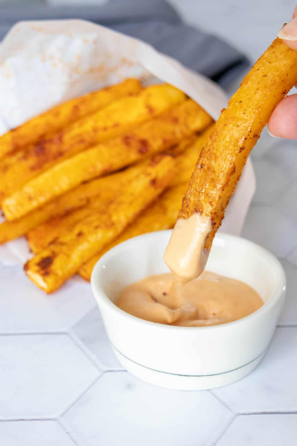 Dipping rutabaga fry into burger sauce.