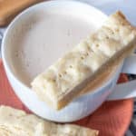 Sliced shortbread cookie resting on a cup of chai.