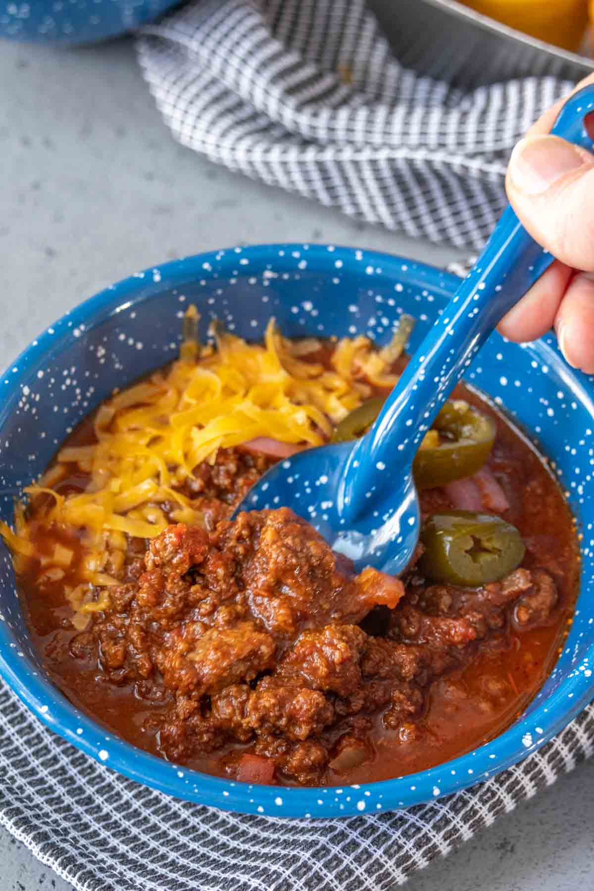 Spoon going into a bowl of bison chili.