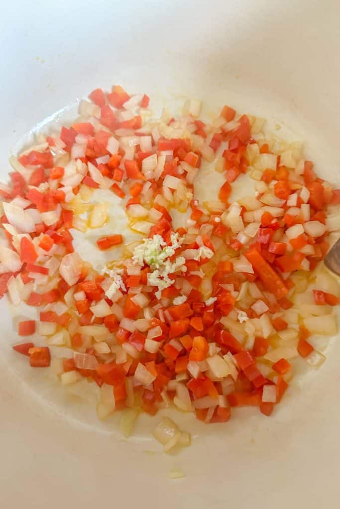 Sauteeing garlic with vegetables in a pot.