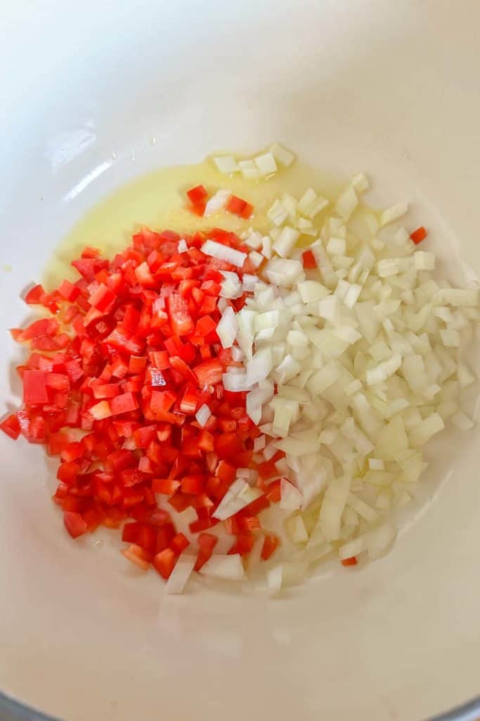 Sauteeing onion and bell pepper in a pot.