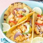 Plate of cauliflower tacos with toppings on a blue plate.