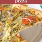 A slice of chicken pesto pizza with tomatoes, red onions, and cheese is being lifted from a hot pizza pan.