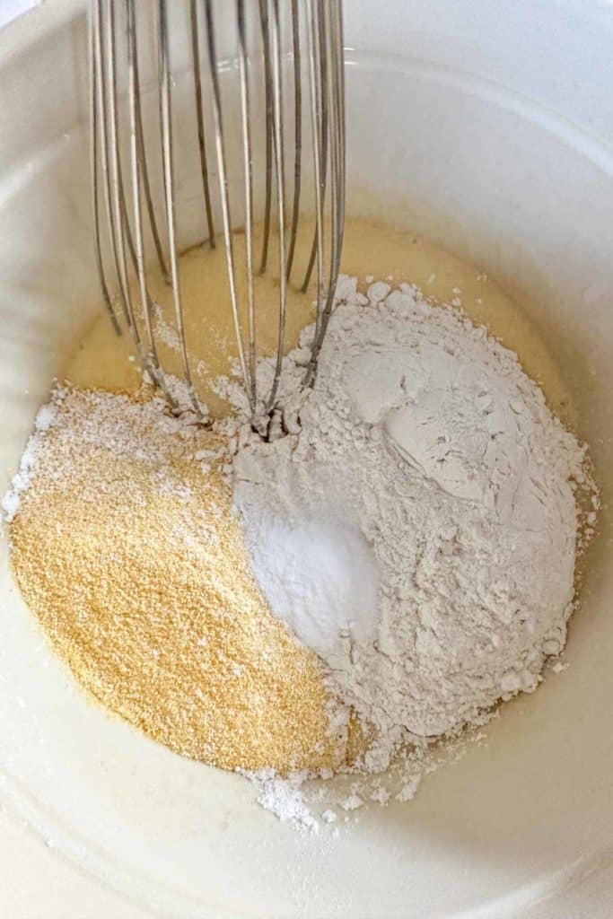 Adding dry ingredients to wet ingredients for corn muffins.
