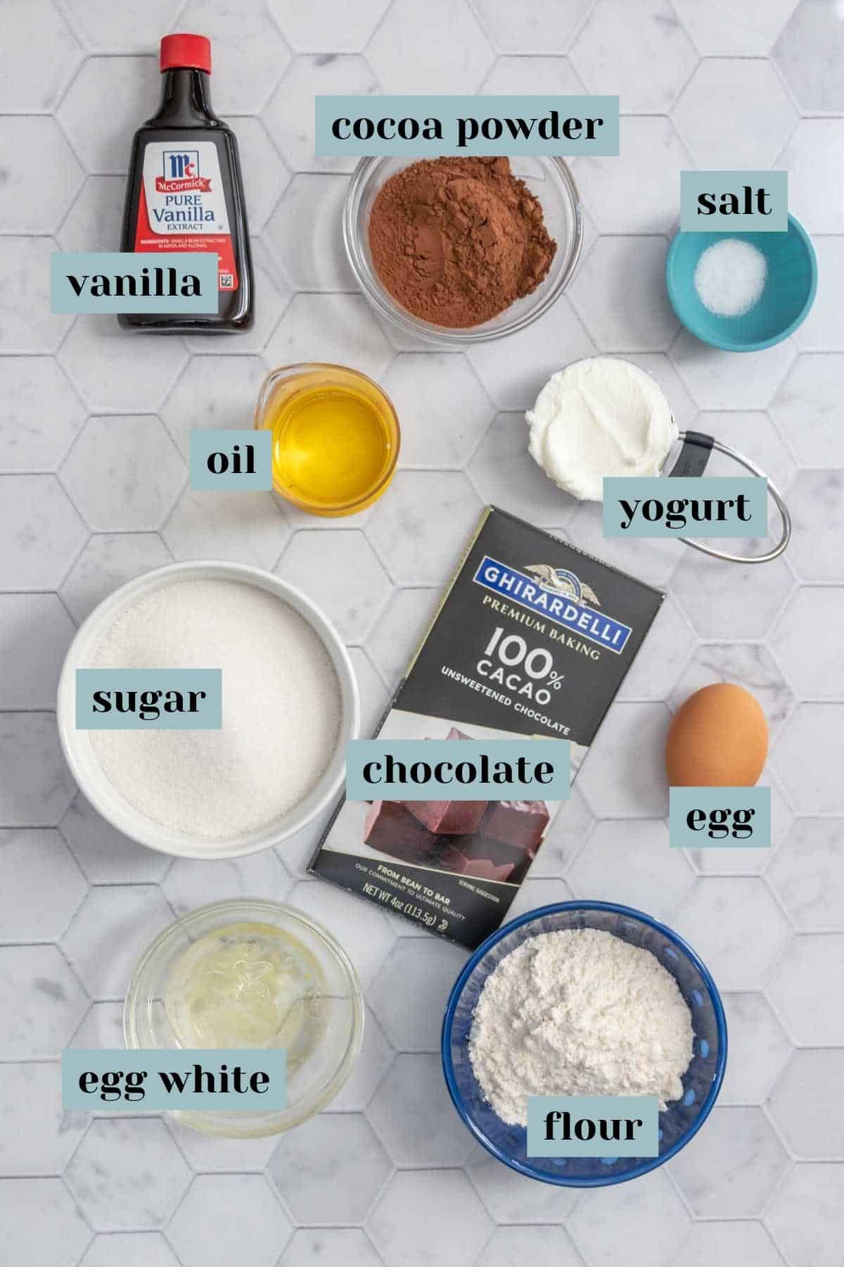 Ingredients for fudgy brownies on a tile surface with labels.