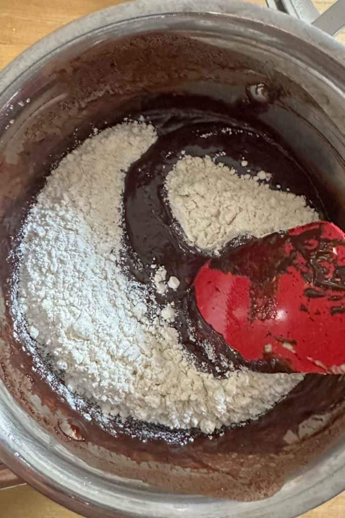 Adding flour to brownie batter.