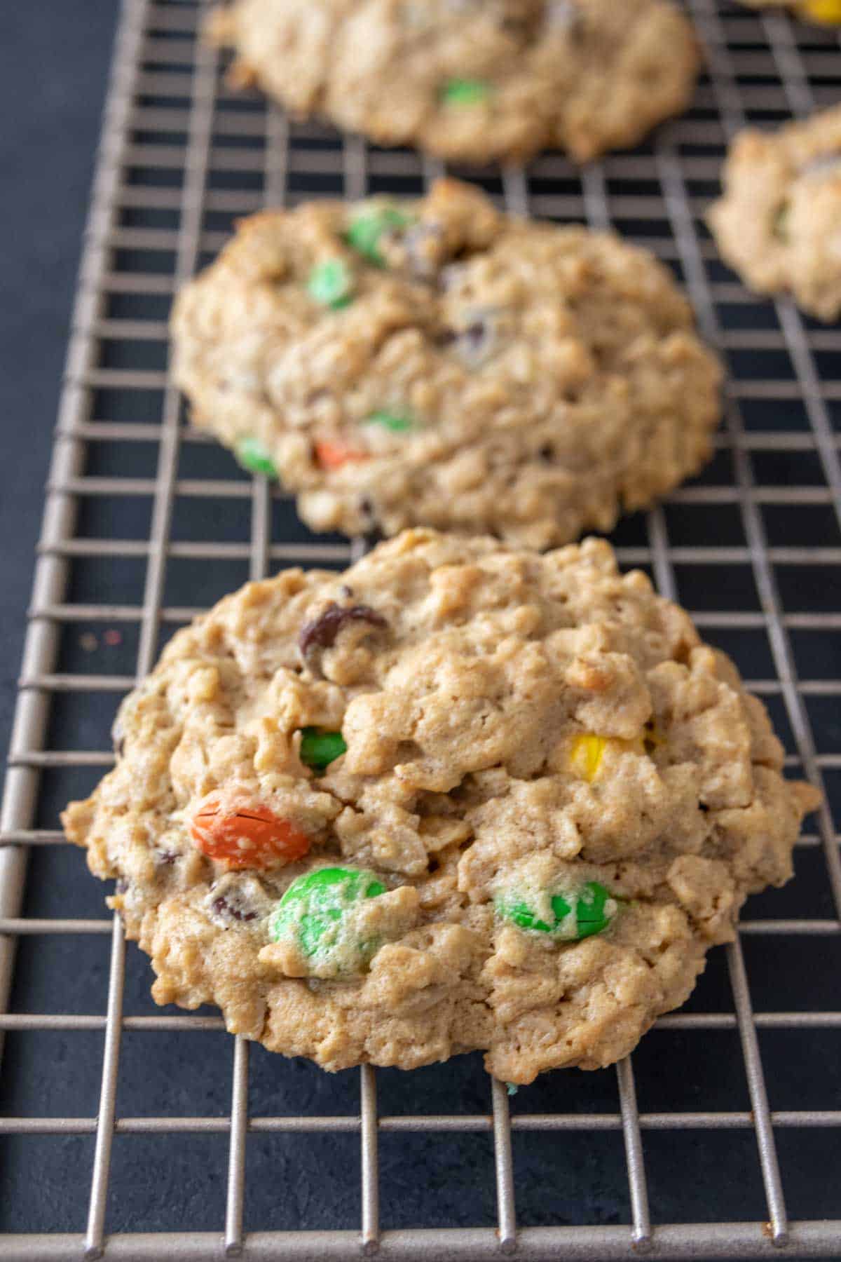 Baked monster cookies on a cooling rack.