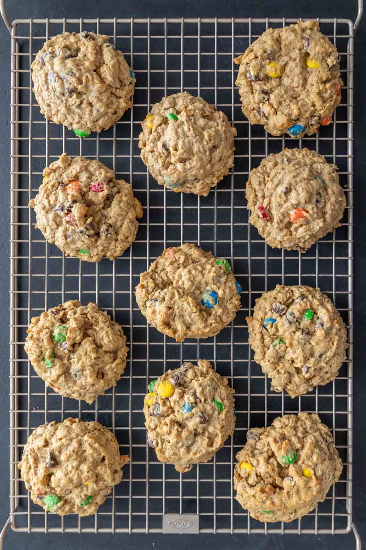 Overhead of baked monster cookies on cooling rack.