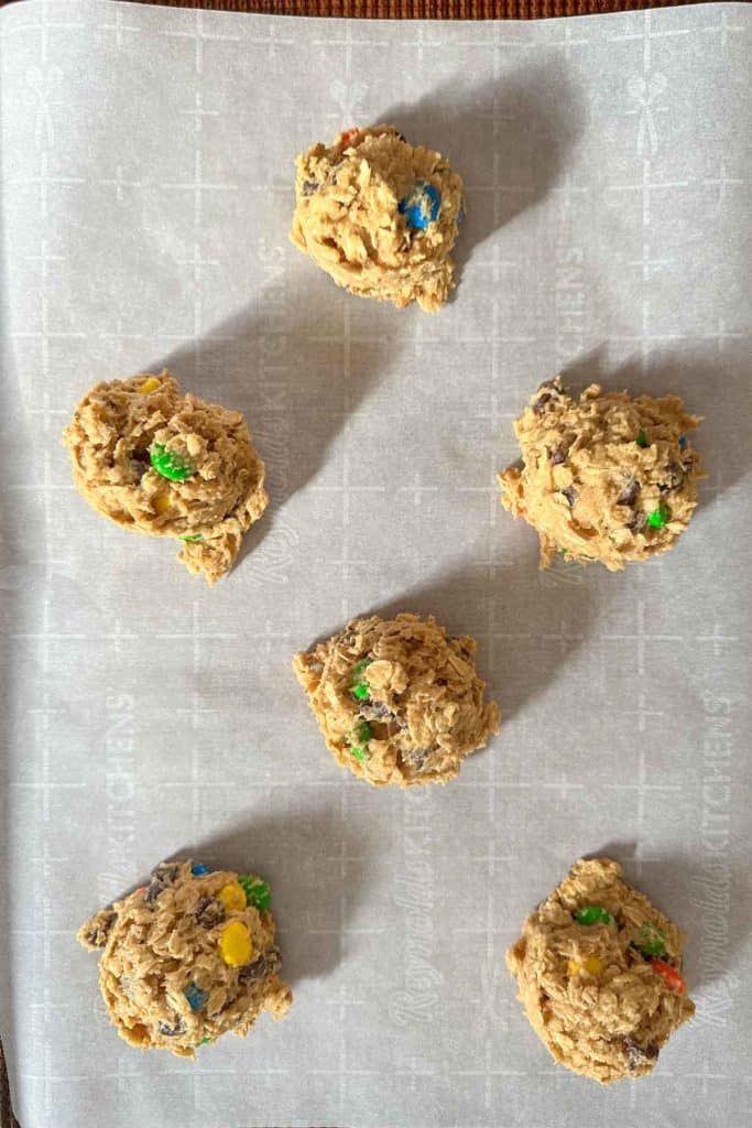Monster cookie dough balls on baking sheet.