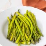 White serving platter filled with roasted asparagus.