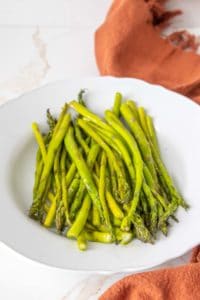 White serving platter filled with roasted asparagus.