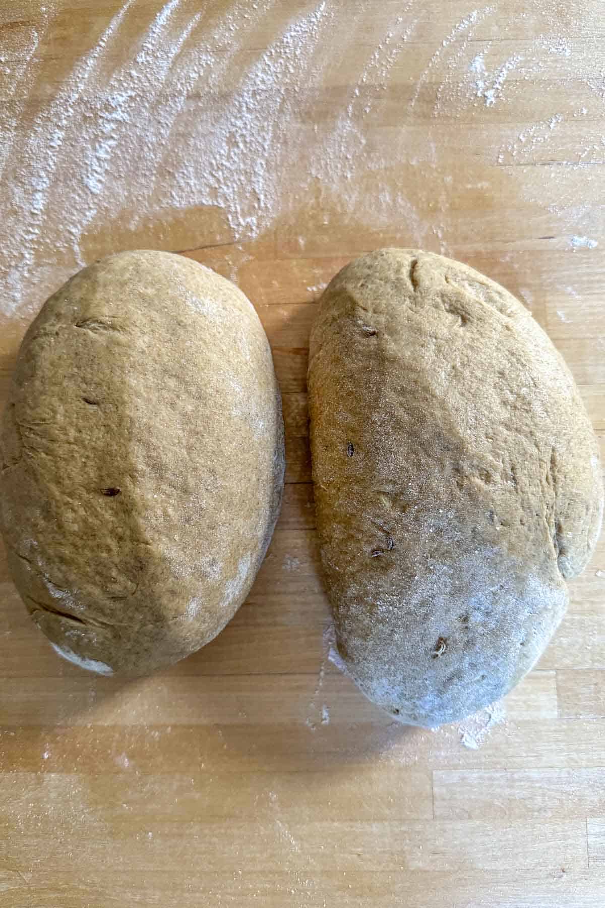 Limpa dough divided in half on a wooden surface.