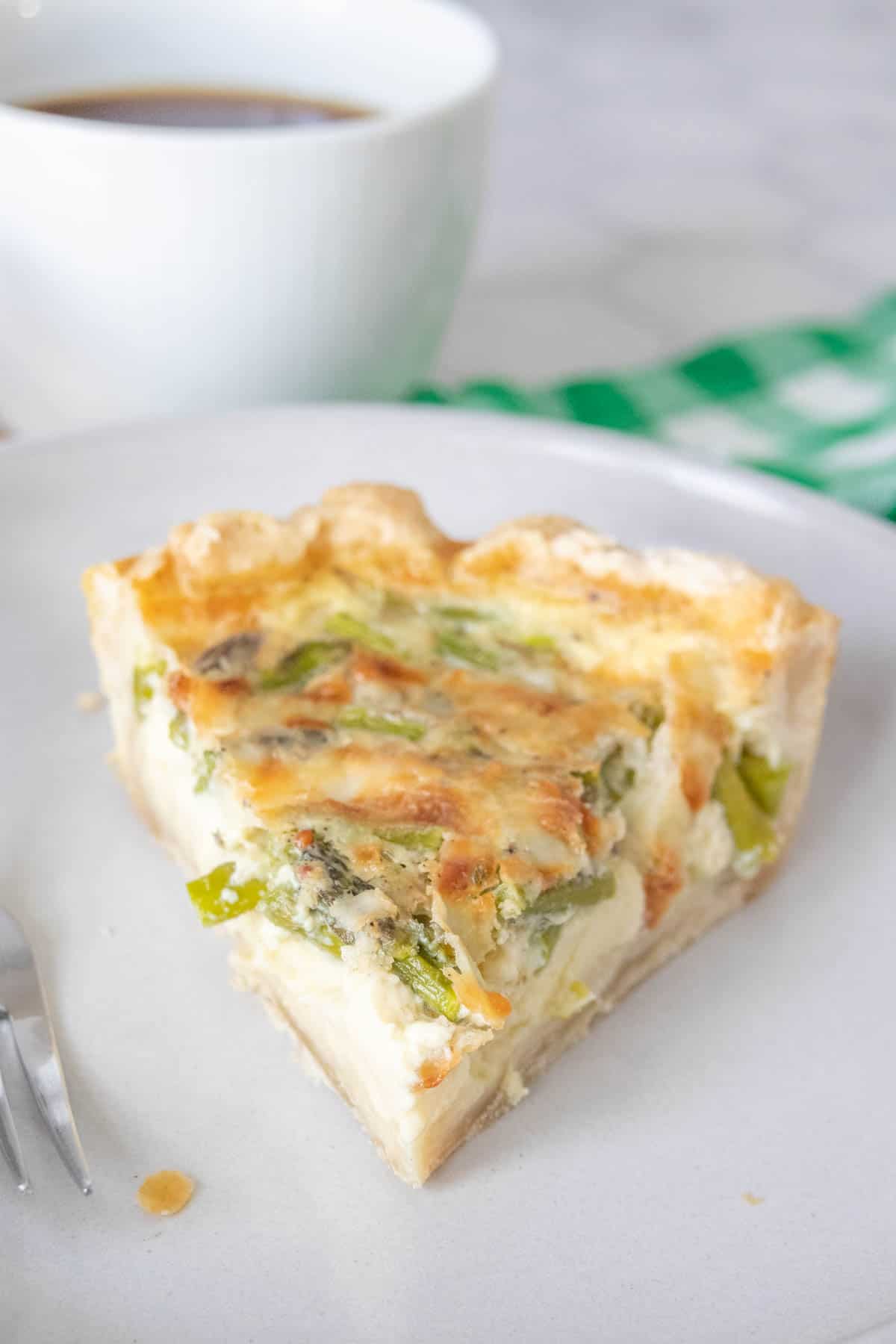Slice of asparagus quiche with the point facing the camera.