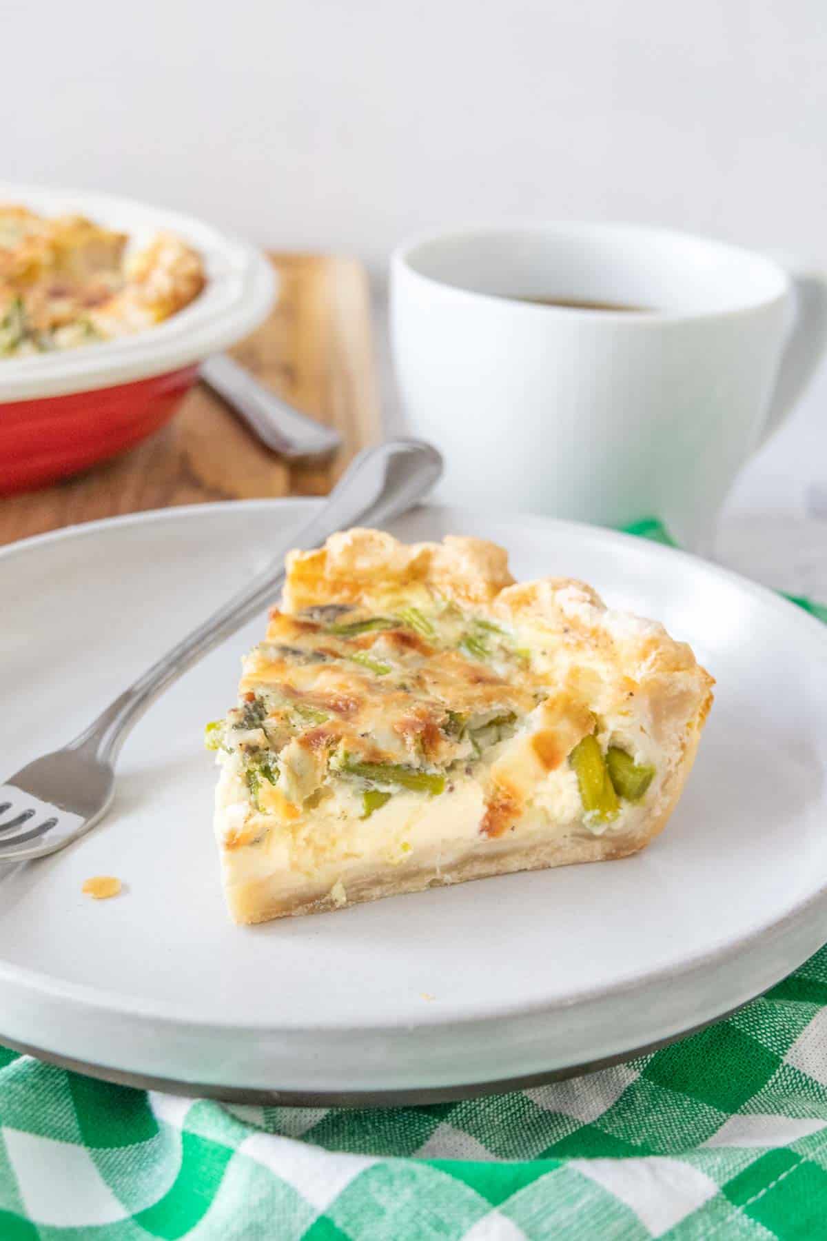 Slice of asparagus quiche on a gray plate.