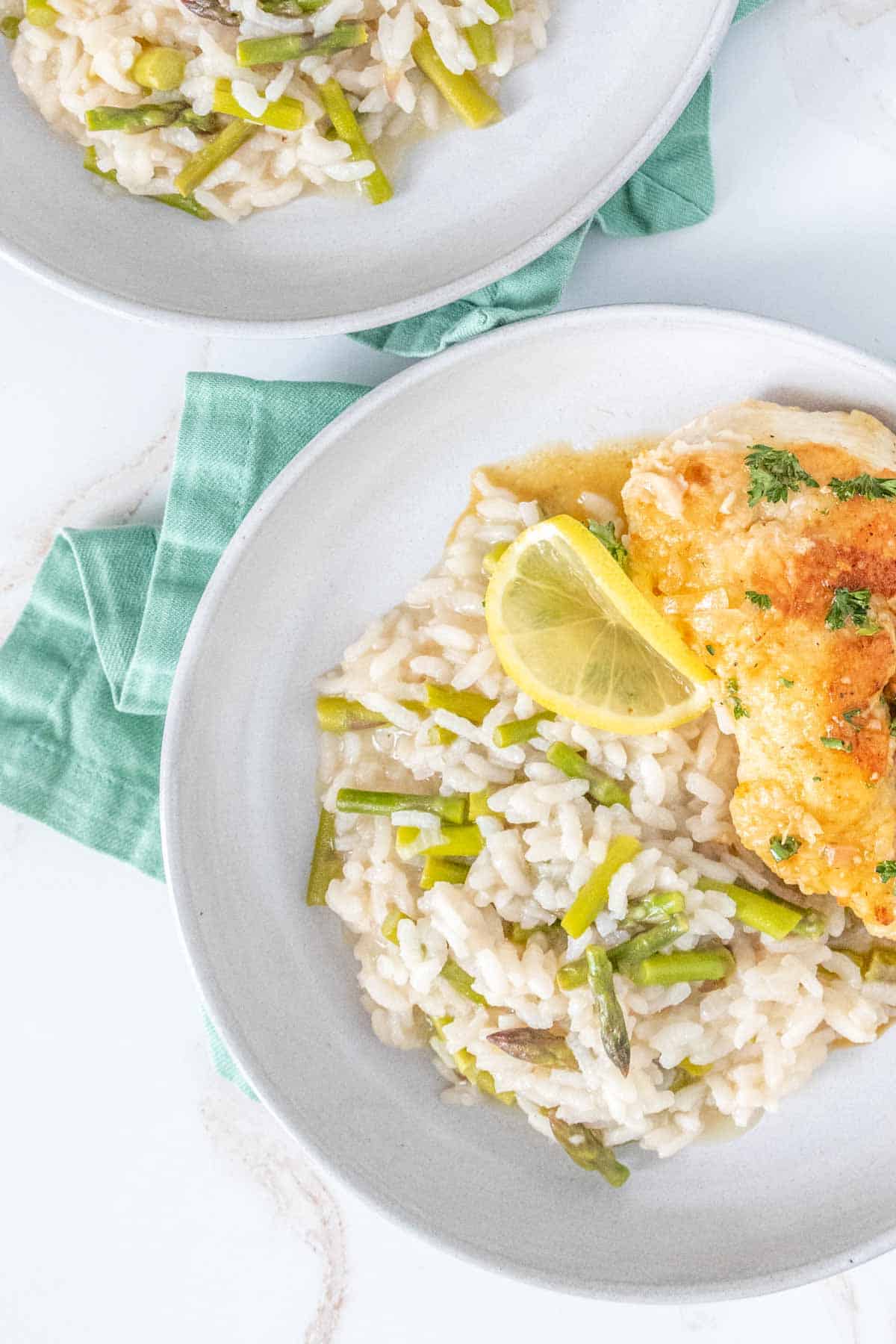 Asparagus risotto on plates with chicken.