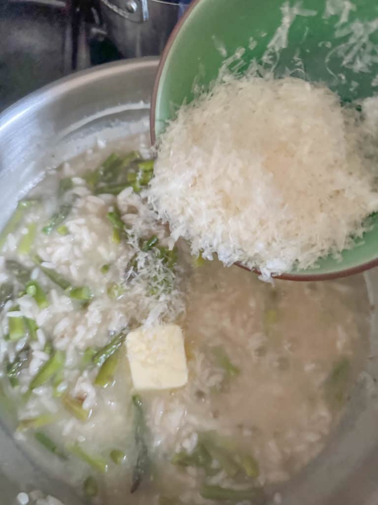 Adding cheese and butter to asparagus risotto.