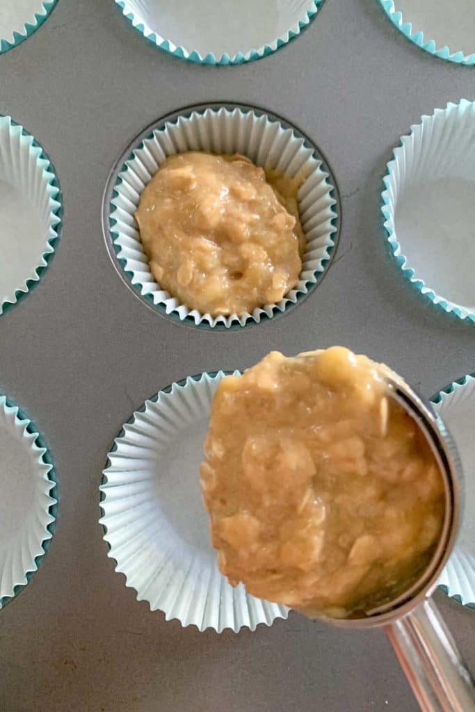 Scooping banana muffin batter into pan.