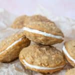 Pile of carrot cake cookies on parchment paper.