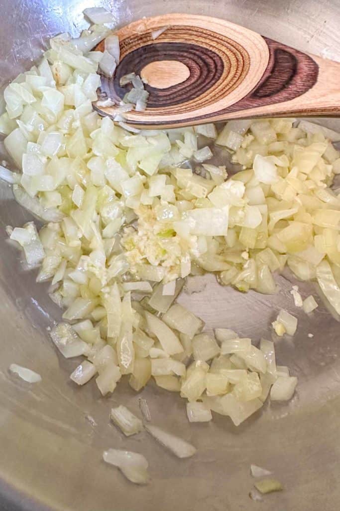 Sauteeing onions in a stainless steel pan.