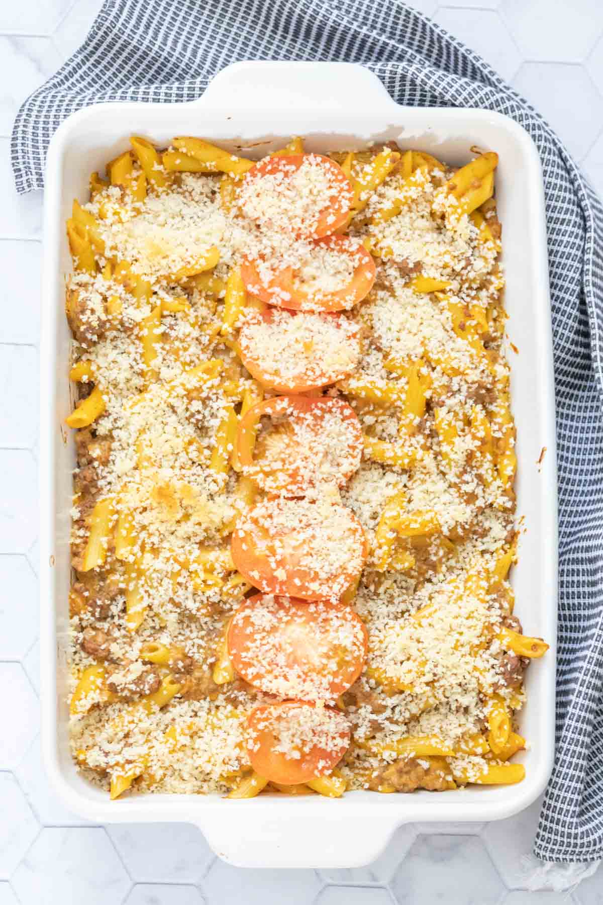 White casserole dish filled with baked cheeseburger mac and cheese.