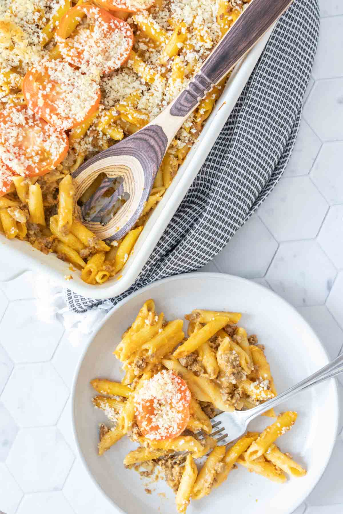 Plate of cheeseburger mac and cheese next to casserole dish.