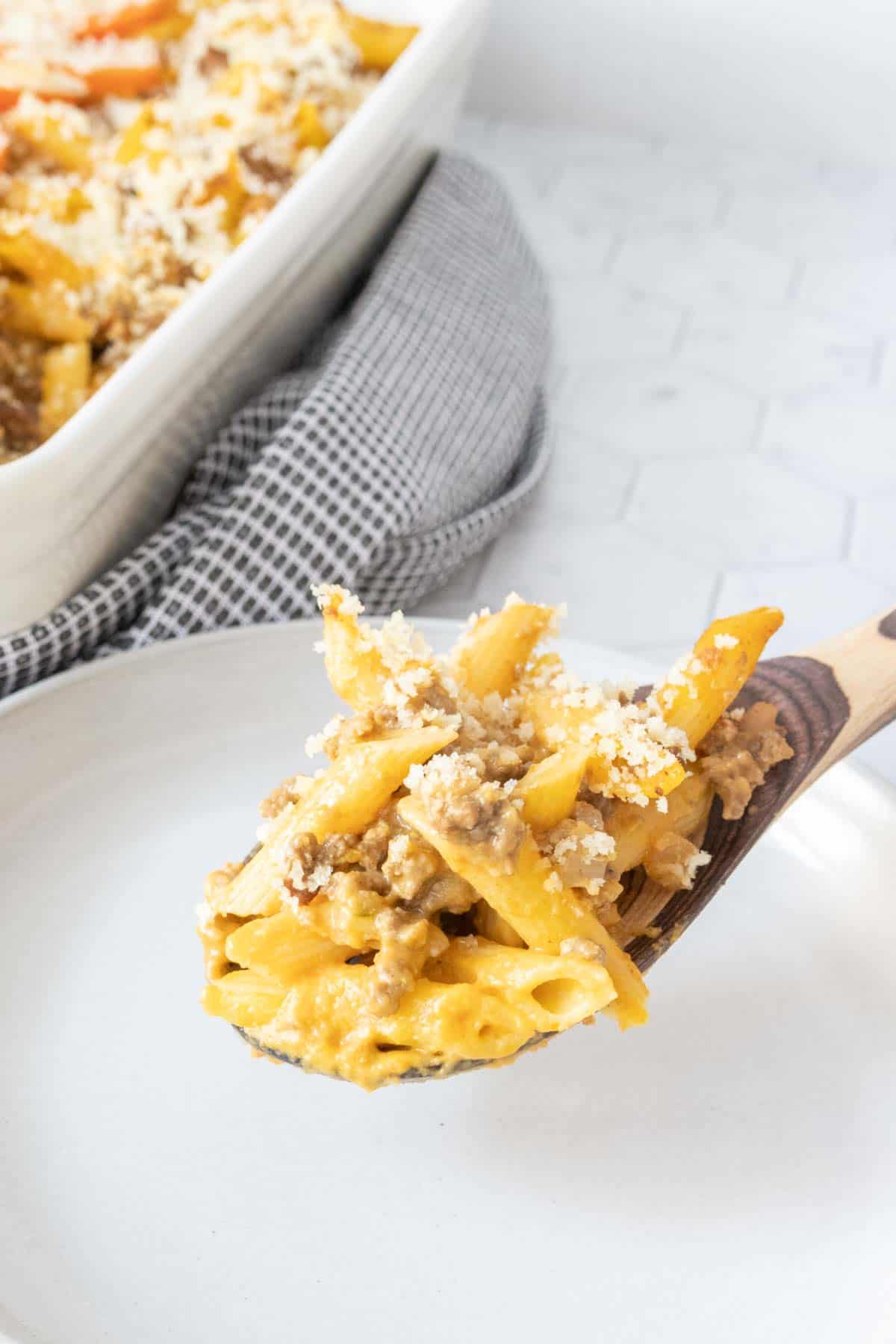 Wooden spoon serving cheeseburger mac and cheese.