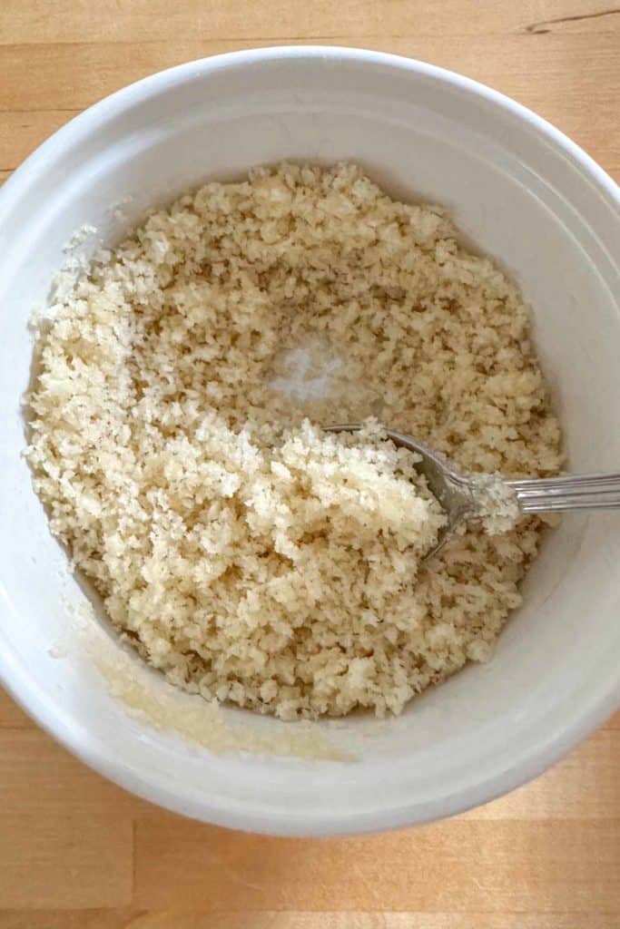 Mixing panko and melted butter together in bowl.