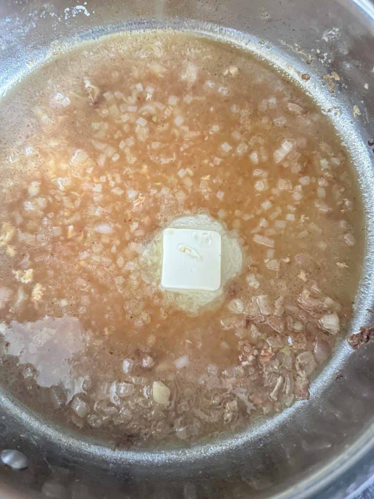 Melting butter in saute pan of sauce.