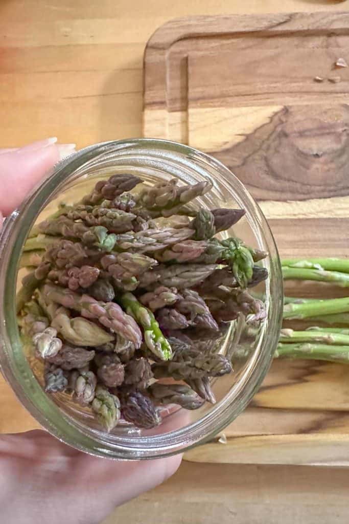 Stuffing jar with asparagus for pickling.