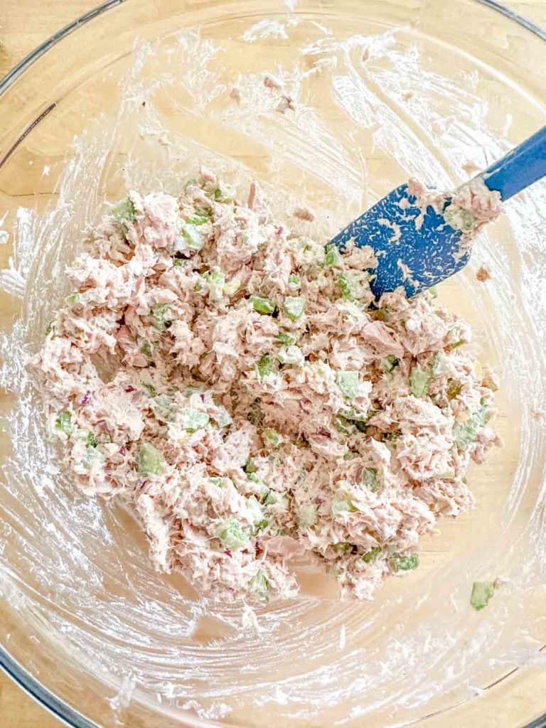 Tuna salad in a glass mixing bowl.