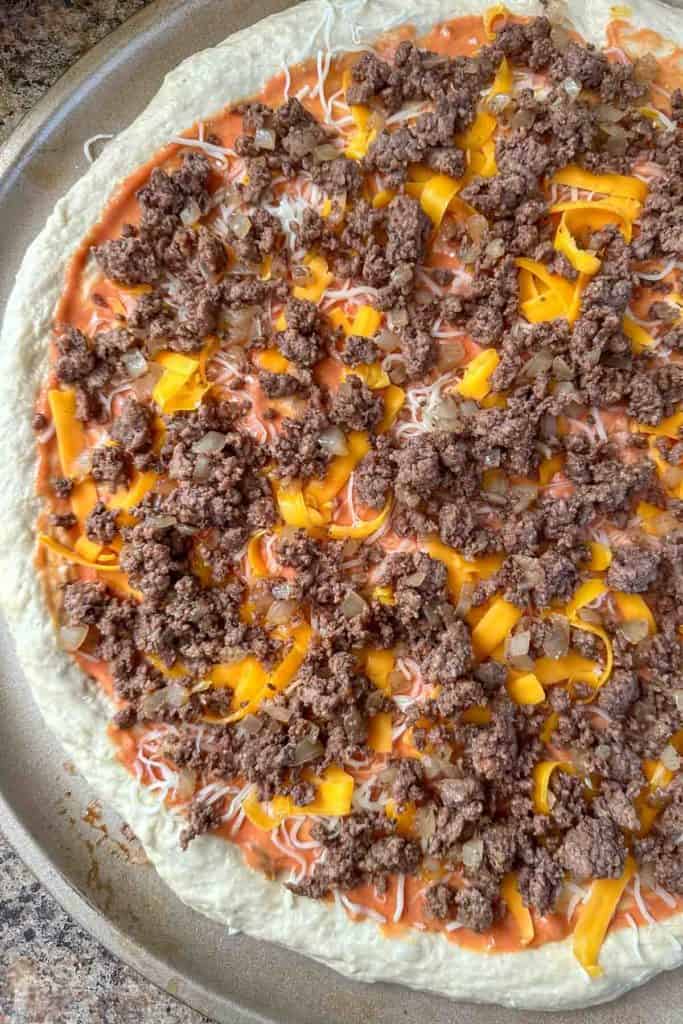Unbaked cheeseburger pizza.